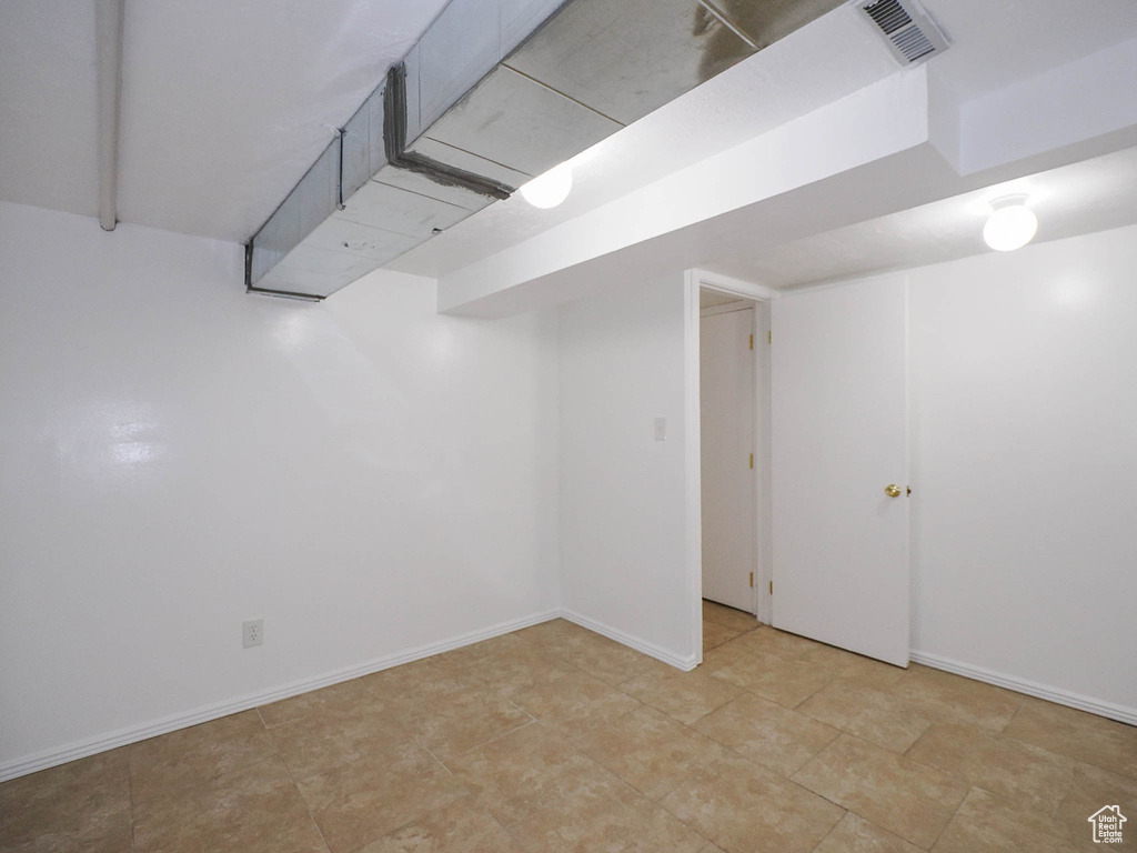 Finished basement featuring visible vents and baseboards