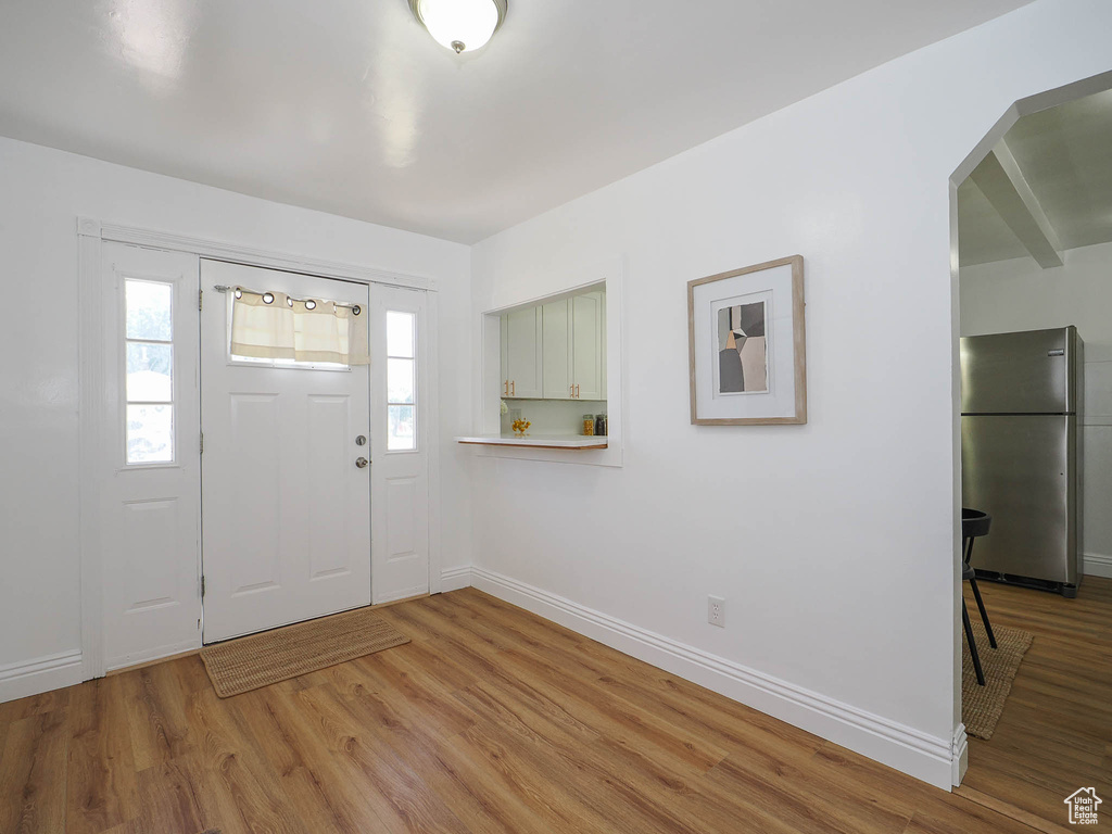 Entrance foyer featuring arched walkways, wood finished floors, and baseboards