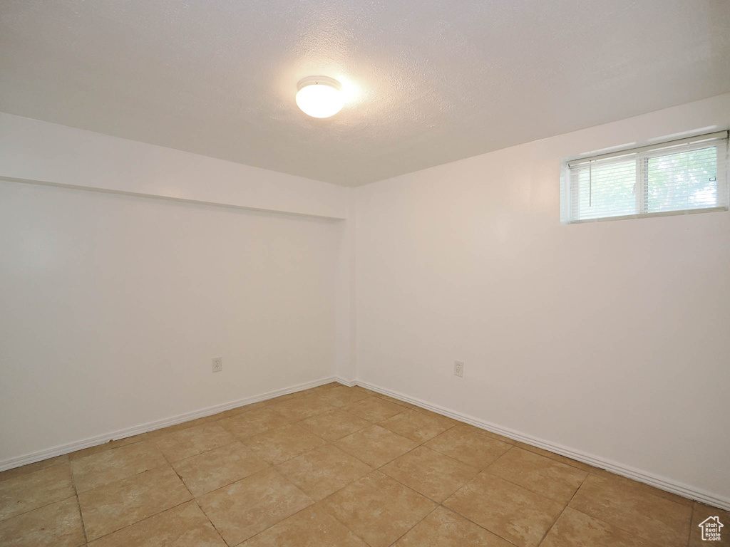 Empty room featuring a textured ceiling and baseboards