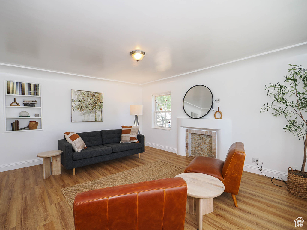 Living area with light wood-type flooring, a fireplace, and baseboards