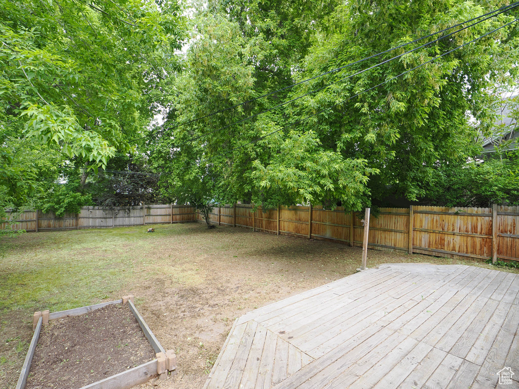 View of yard with a fenced backyard, a vegetable garden, and a wooden deck