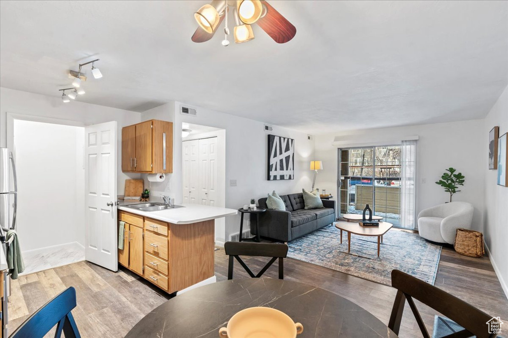 Kitchen featuring light countertops, visible vents, open floor plan, a sink, and light wood-type flooring