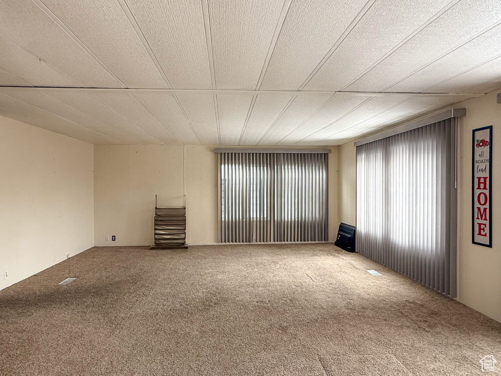 Carpeted empty room featuring a textured ceiling