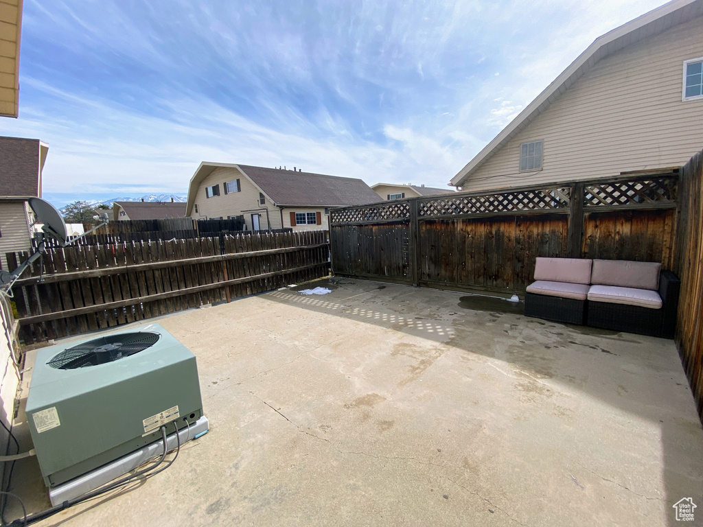 View of patio with central air condition unit and a fenced backyard