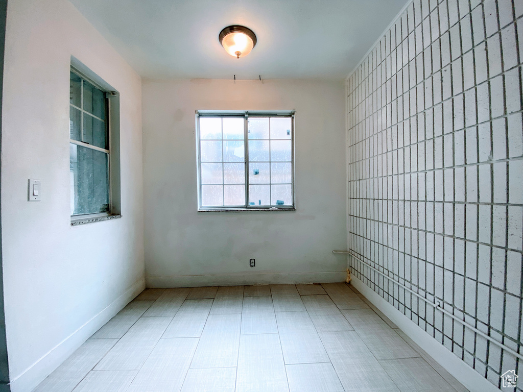 Empty room featuring tile walls