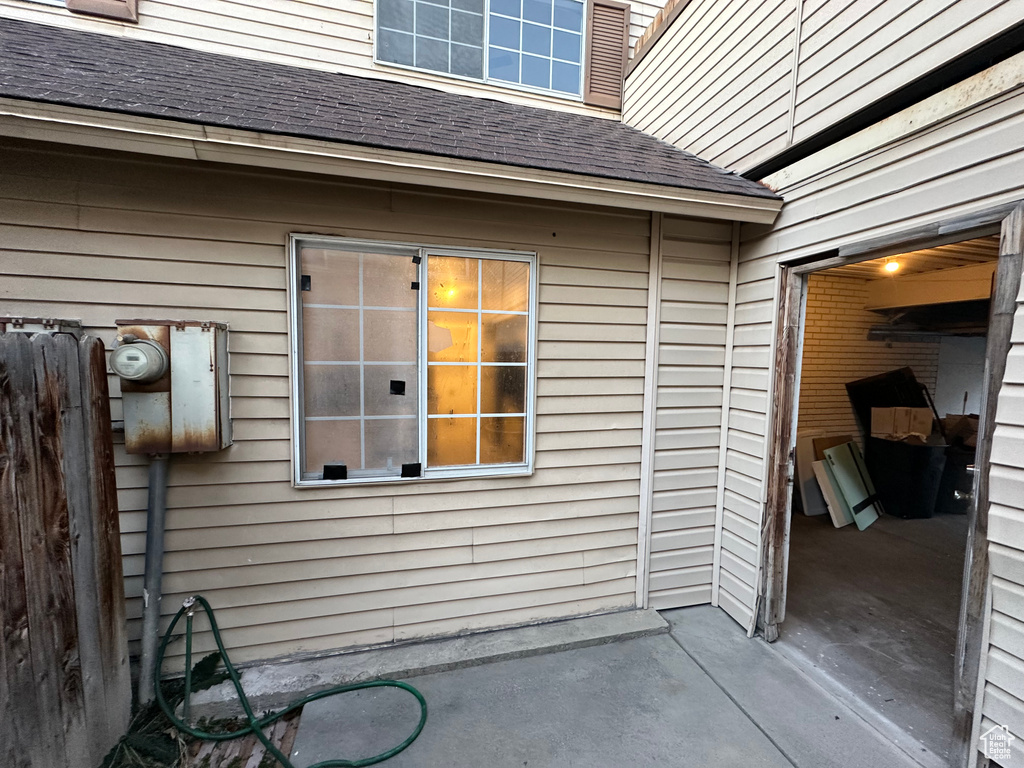 Exterior space featuring roof with shingles and a patio