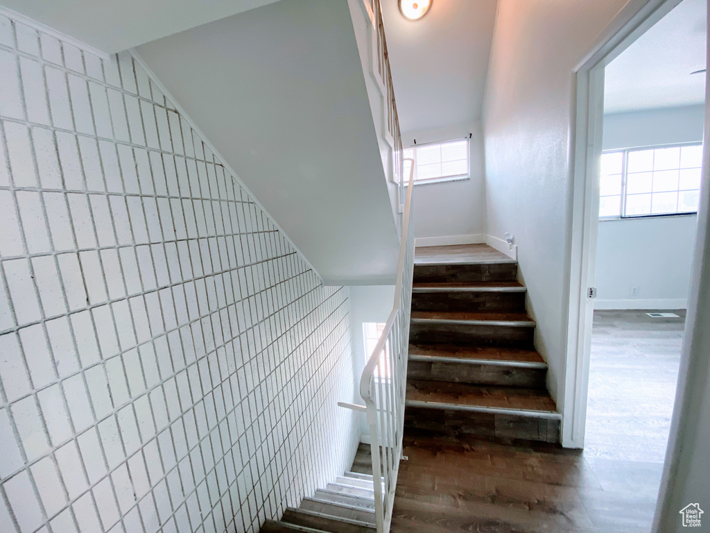 Stairway featuring wood finished floors