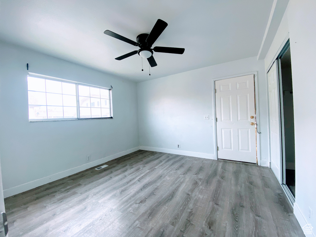 Empty room with visible vents, a ceiling fan, light wood-style flooring, and baseboards