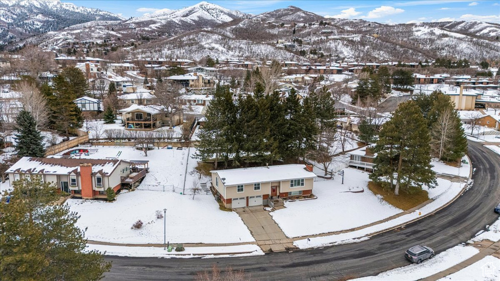 Snowy aerial view featuring a residential view and a mountain view