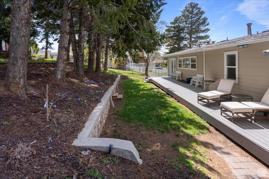 View of yard with fence and a deck