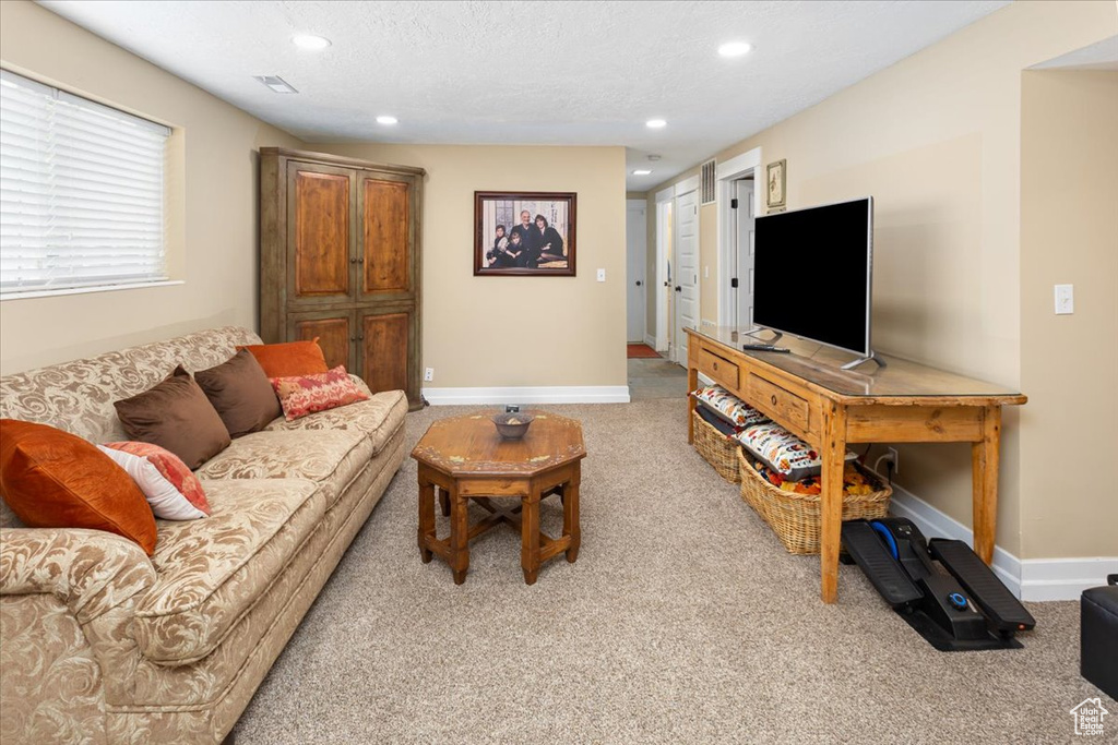 Living area with visible vents, baseboards, recessed lighting, and light colored carpet