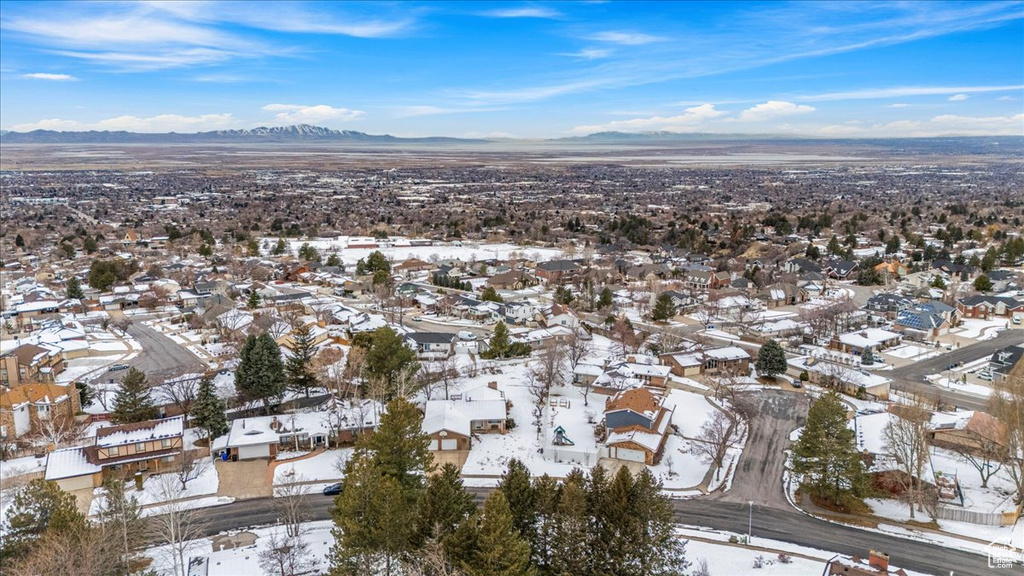 Snowy aerial view featuring a residential view and a mountain view