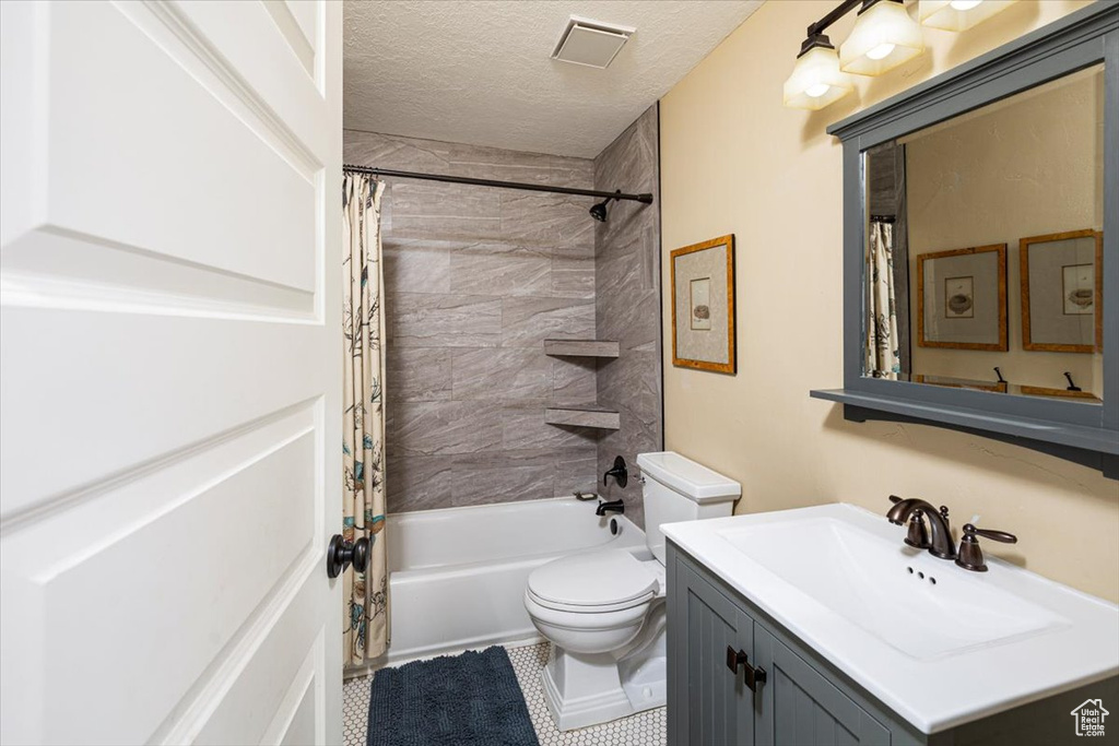 Full bath featuring visible vents, toilet, shower / bath combo, a textured ceiling, and vanity