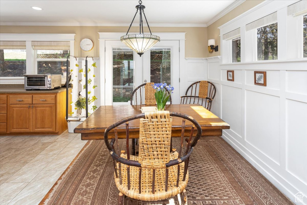 Dining space with a decorative wall, ornamental molding, and a toaster