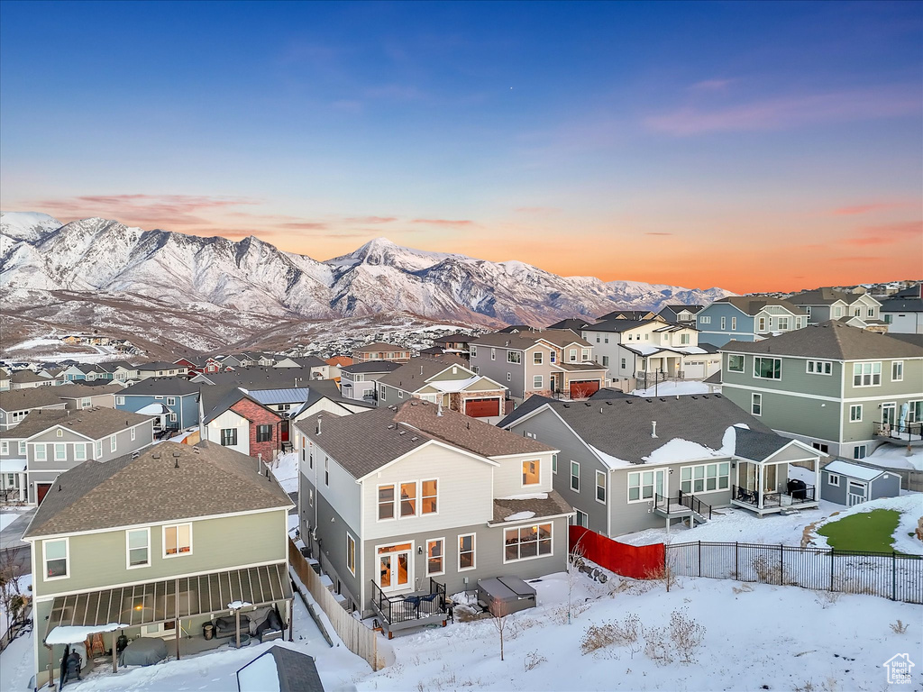 Snowy aerial view featuring a residential view and a mountain view