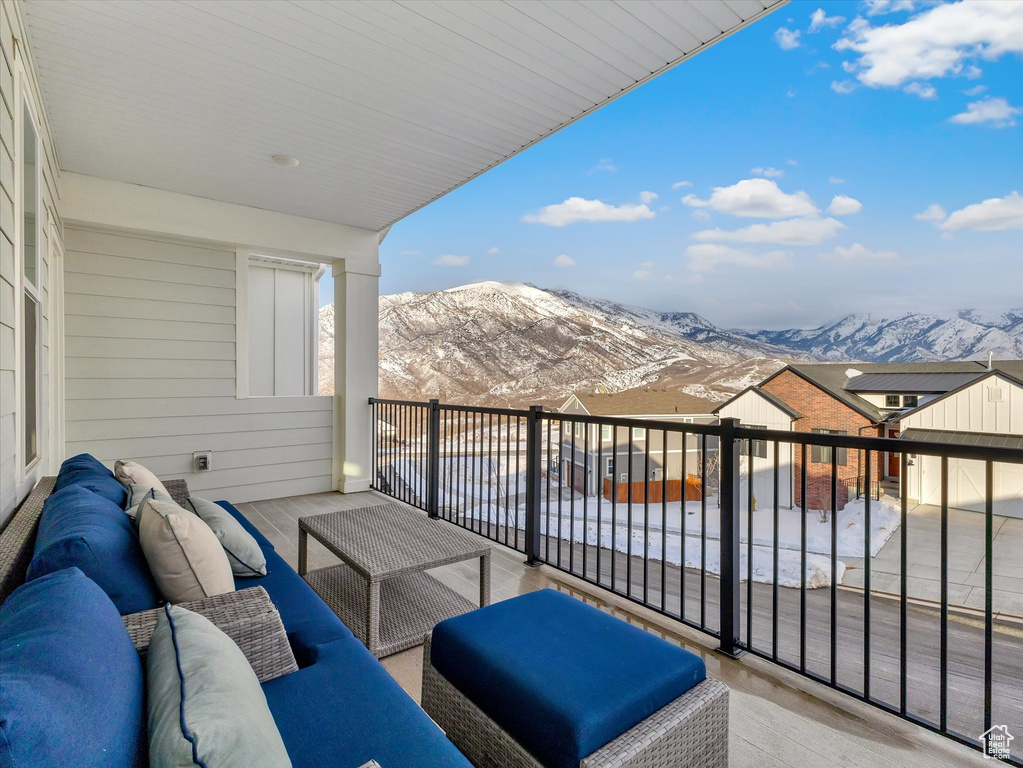 Snow covered back of property with an outdoor hangout area and a mountain view