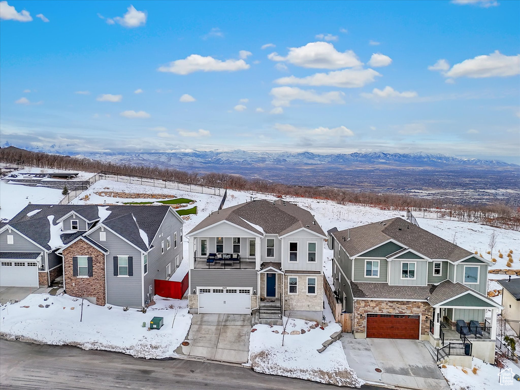 Snowy aerial view featuring a residential view and a mountain view