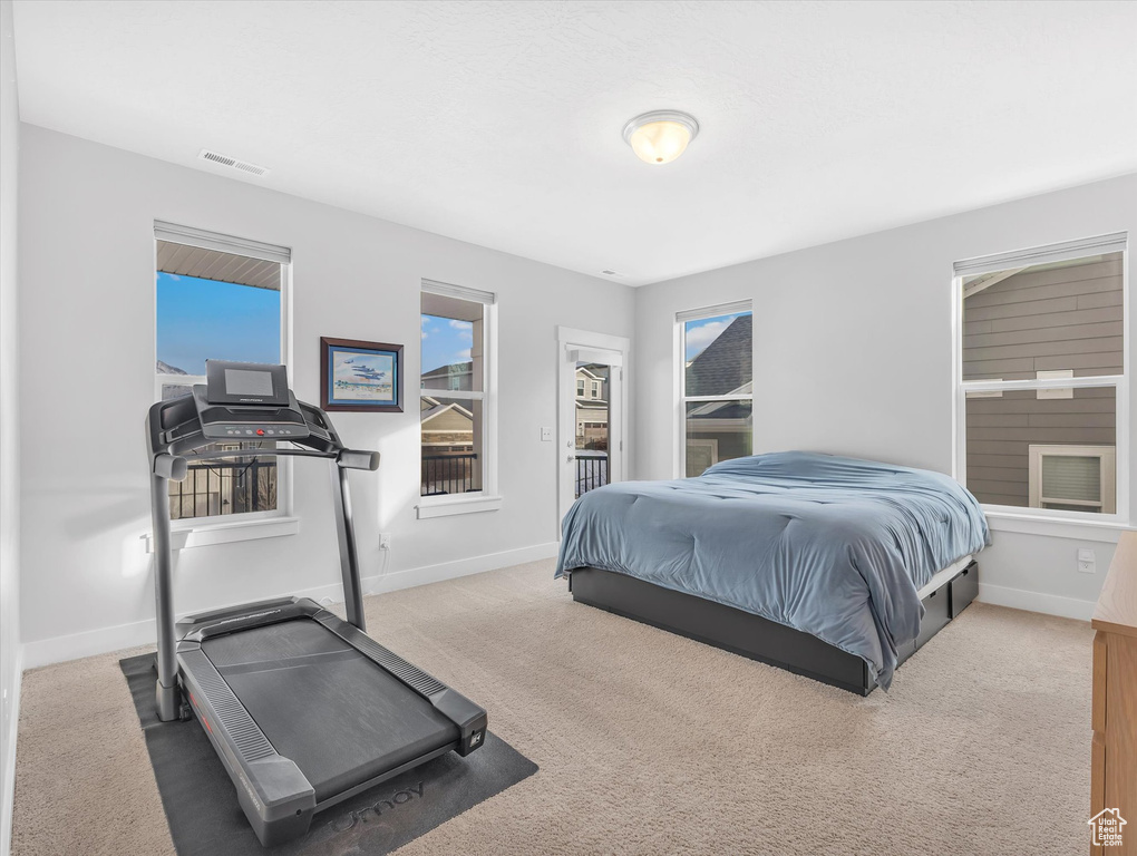 Carpeted bedroom featuring baseboards and visible vents