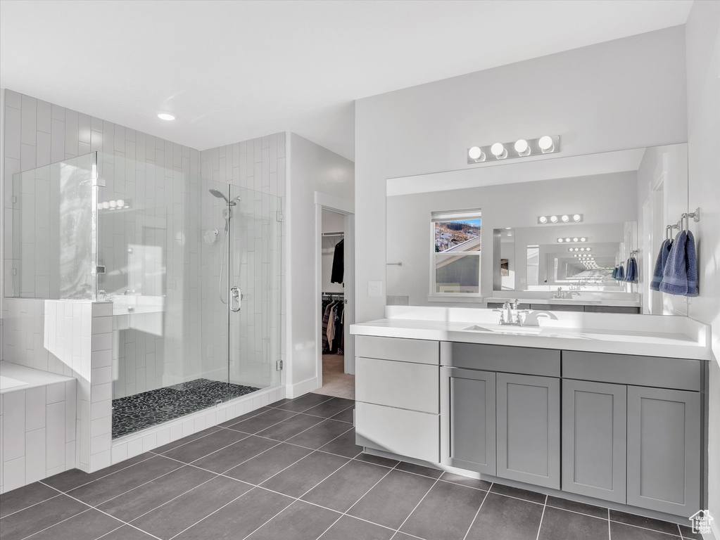 Bathroom featuring a spacious closet, a stall shower, vanity, and tile patterned floors