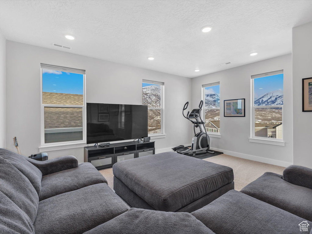 Living room featuring visible vents, a textured ceiling, and light colored carpet