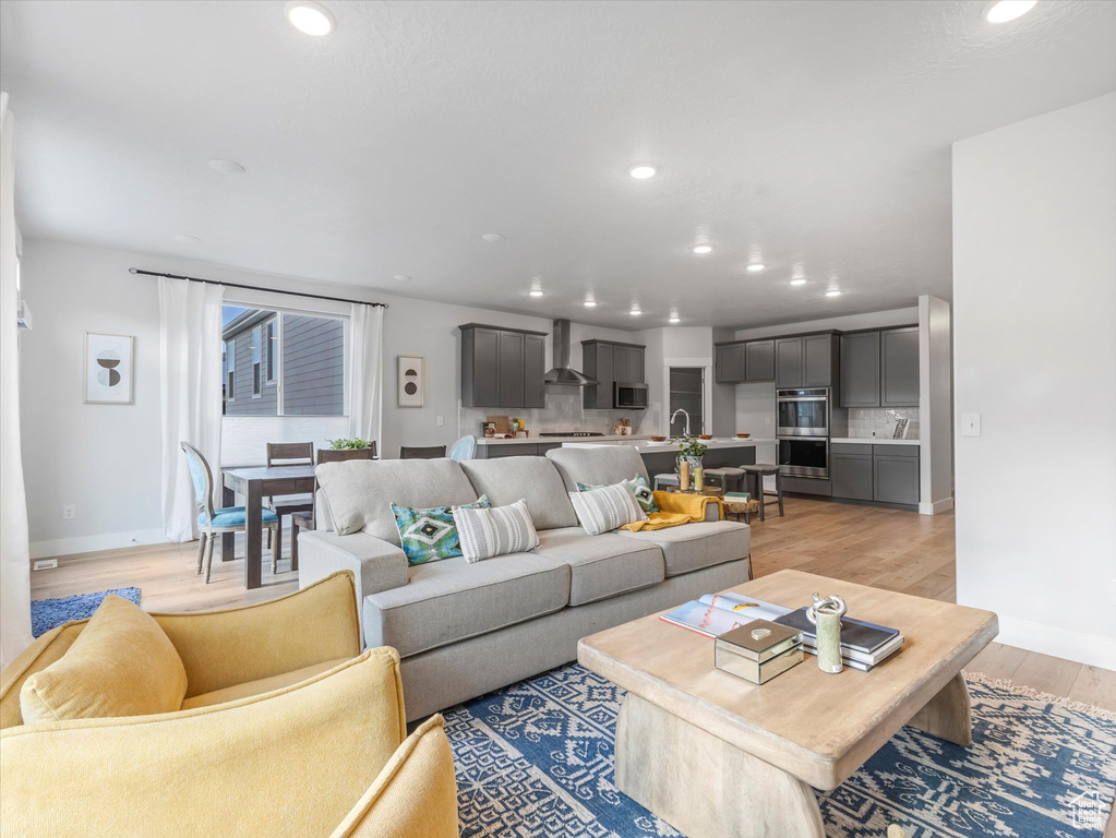 Living room with light wood-style flooring and recessed lighting