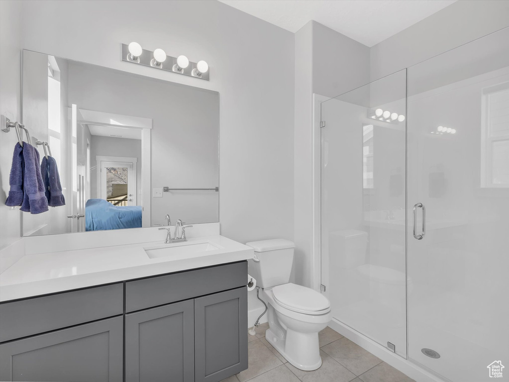 Ensuite bathroom featuring tile patterned flooring, connected bathroom, toilet, vanity, and a stall shower