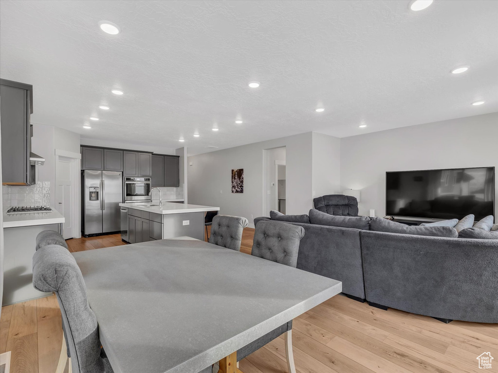 Dining room with light wood-style flooring and recessed lighting