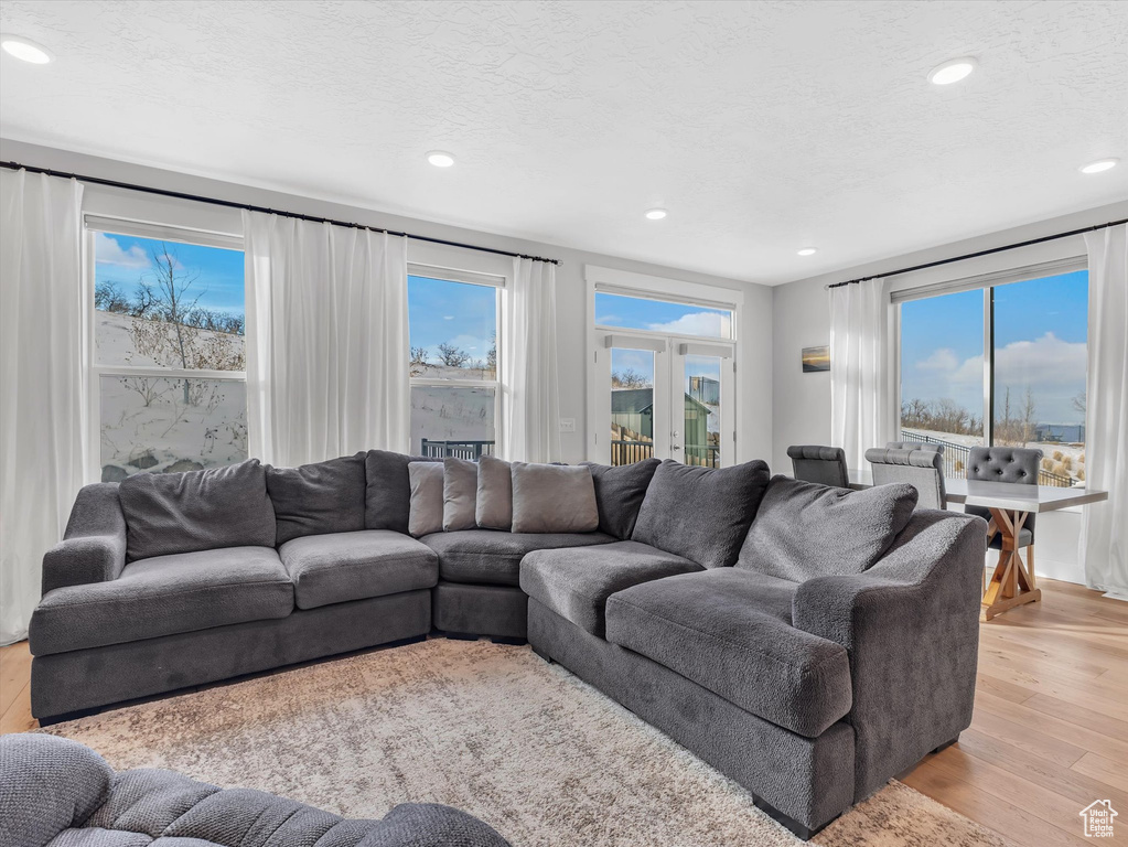 Living room with a textured ceiling, light wood finished floors, and recessed lighting