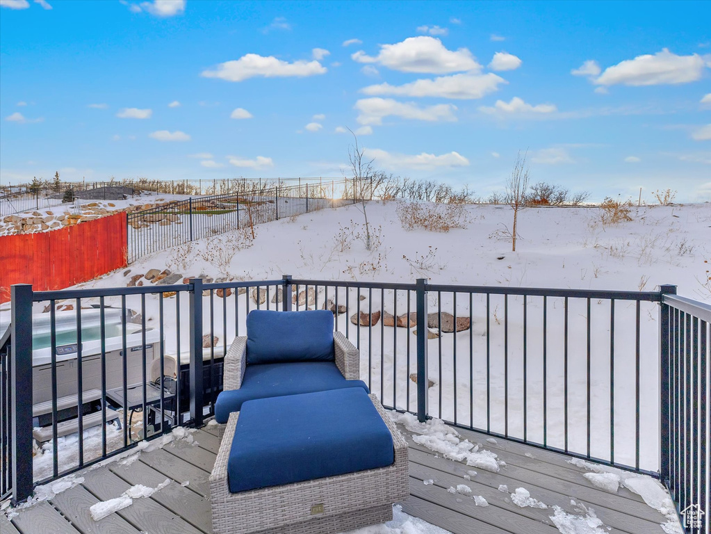 Snow covered deck with a fenced backyard