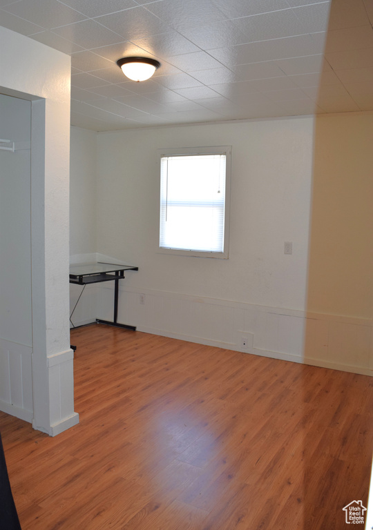 Unfurnished room with a wainscoted wall and wood finished floors