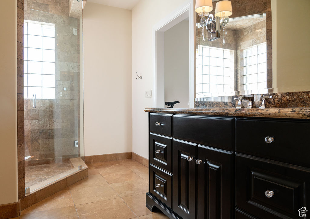 Bathroom with sink, tile patterned flooring, and tiled shower
