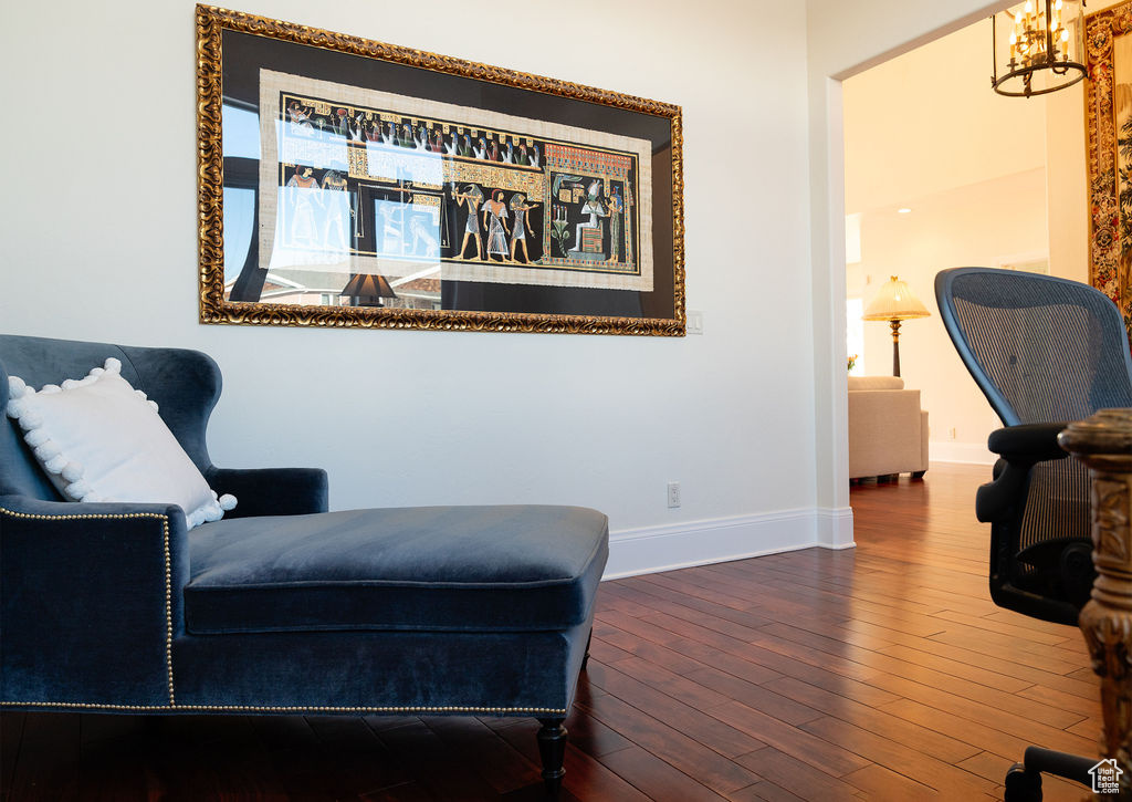 Living area featuring an inviting chandelier and wood-type flooring