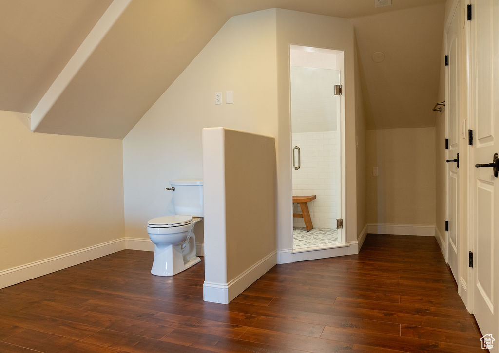 Bathroom with vaulted ceiling, wood-type flooring, and toilet