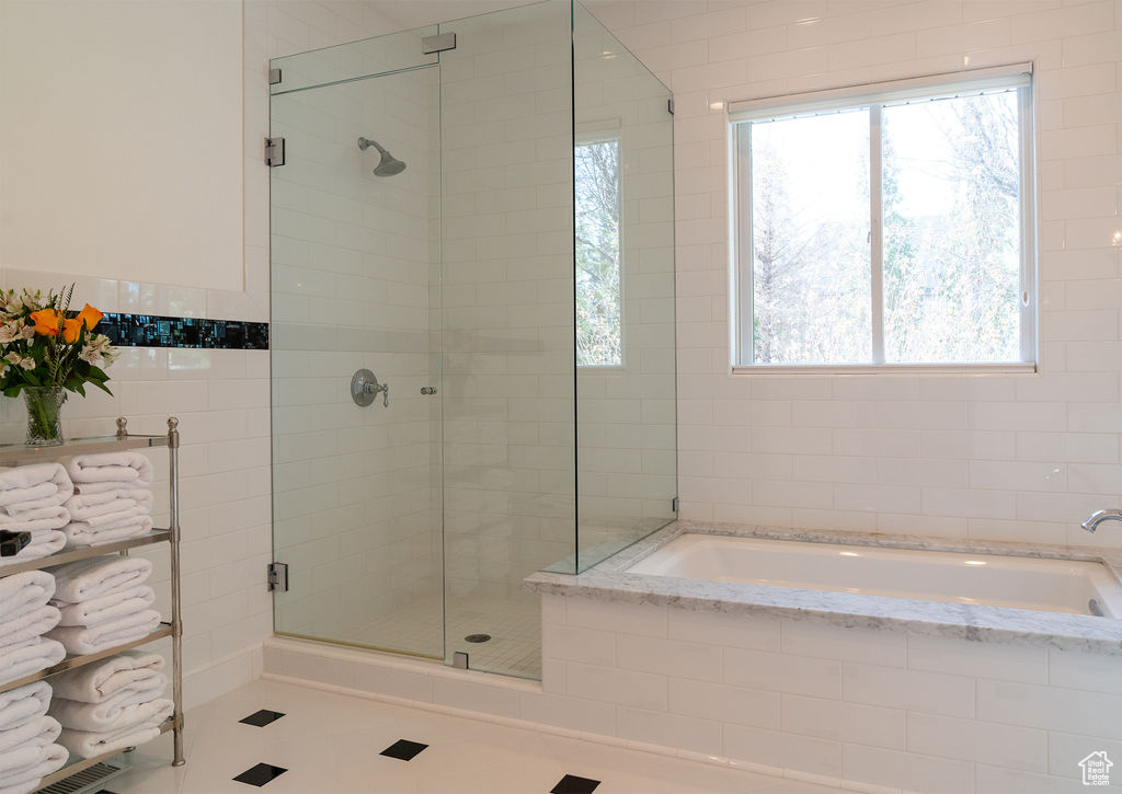 Bathroom featuring plus walk in shower and tile walls