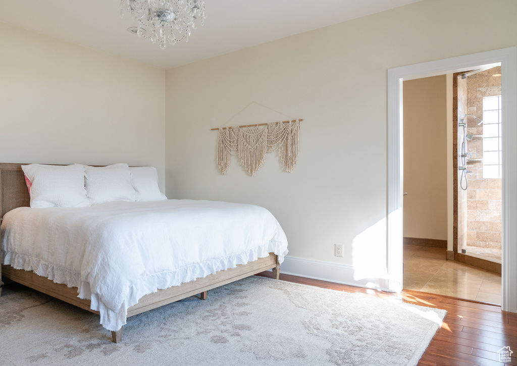 Bedroom with hardwood / wood-style flooring and a notable chandelier