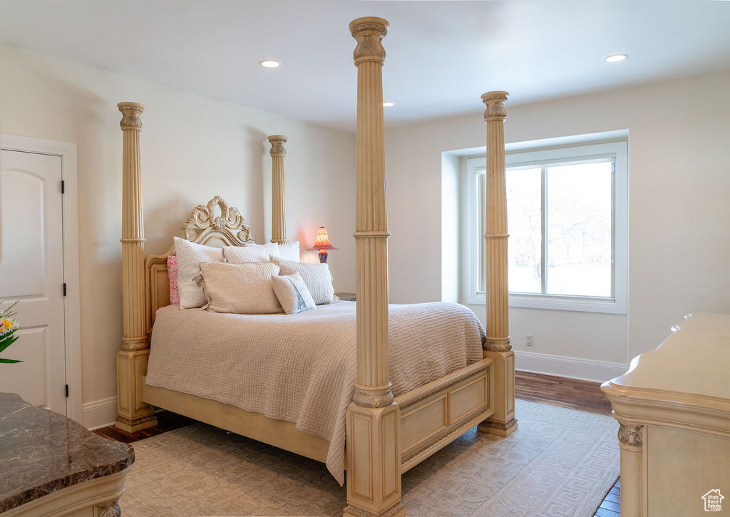 Bedroom with light wood-type flooring and ornate columns