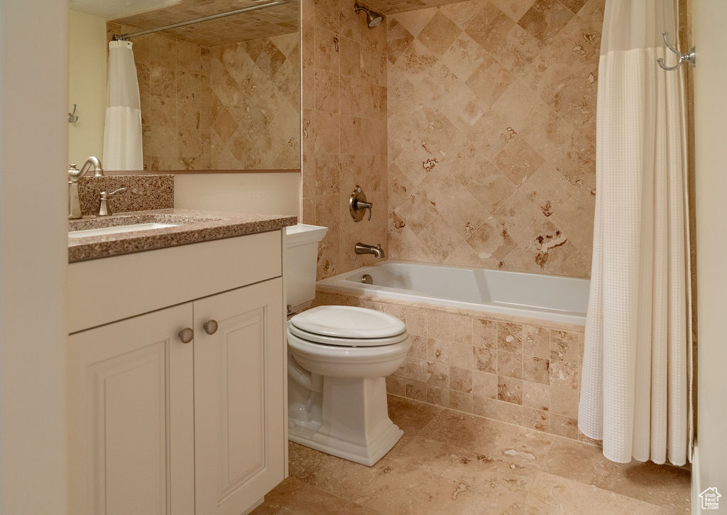 Bathroom with tile patterned floors, shower / tub combo with curtain, and vanity