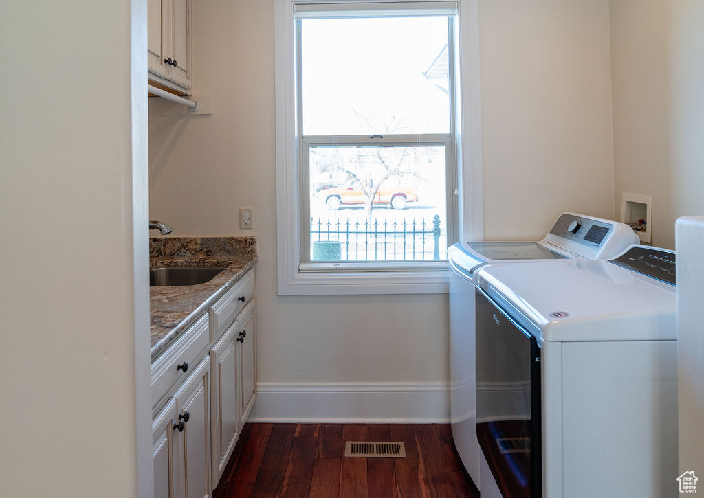 Laundry room featuring cabinets, sink, dark wood-type flooring, and washer and clothes dryer