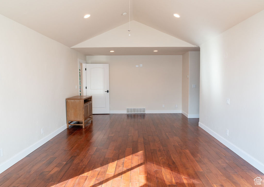 Spare room with lofted ceiling and dark hardwood / wood-style floors