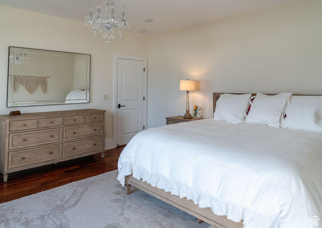 Bedroom featuring dark hardwood / wood-style flooring and a chandelier