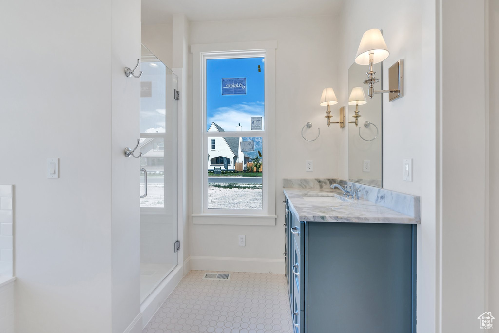 Bathroom featuring vanity and a shower with shower door
