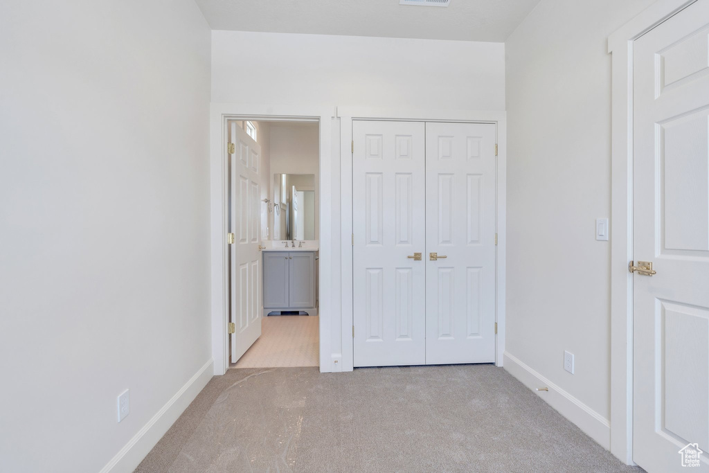 Unfurnished bedroom with carpet, a closet, and ensuite bathroom
