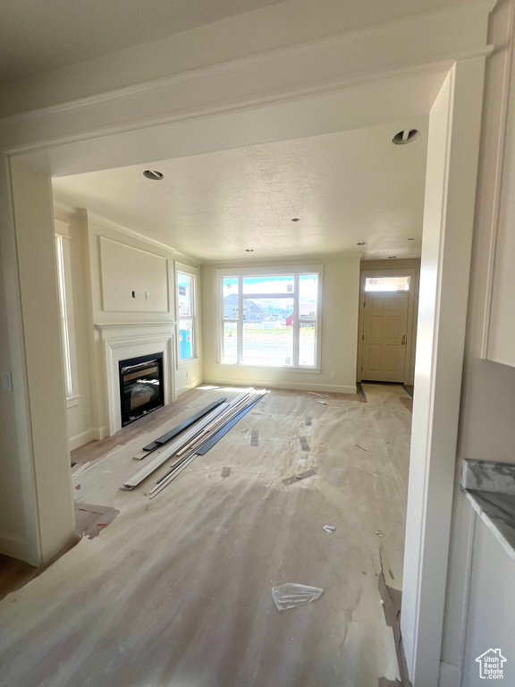 Unfurnished living room featuring a glass covered fireplace