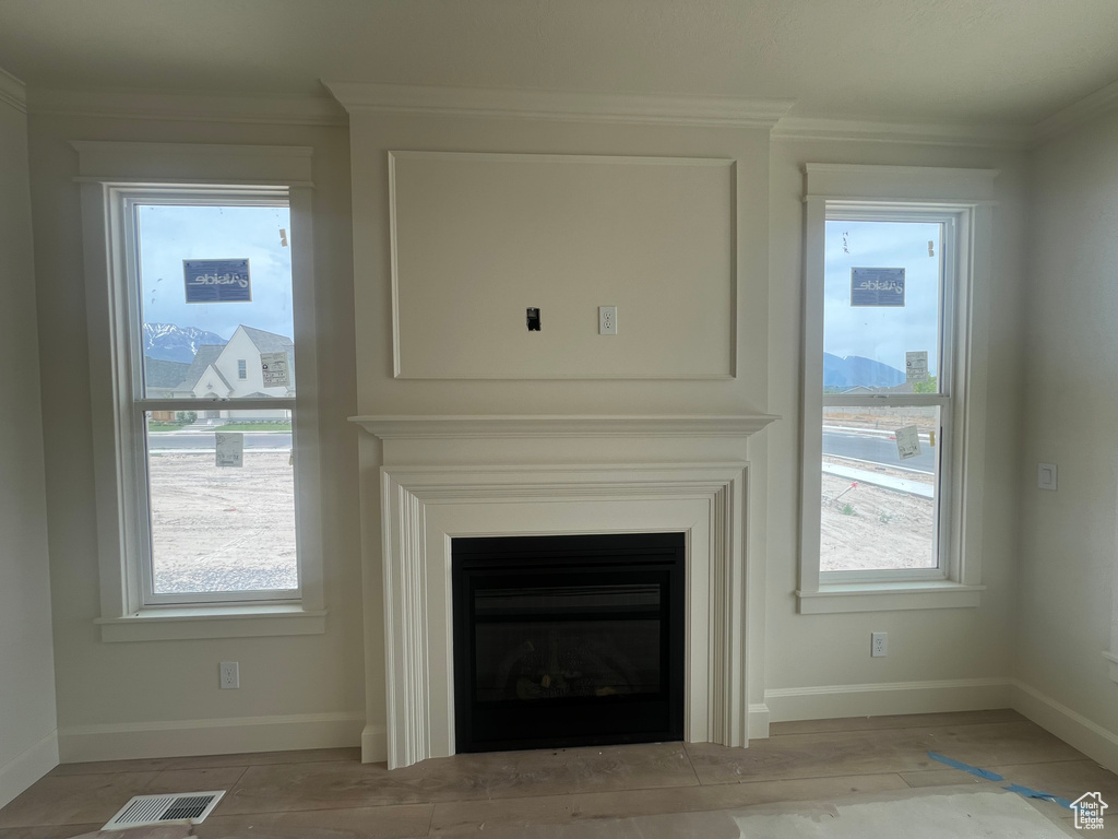 Detailed view of baseboards, a fireplace, and ornamental molding