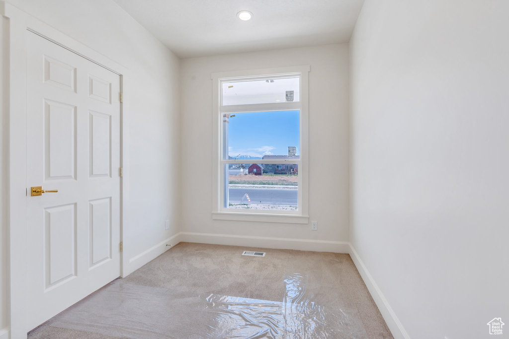 Unfurnished room with light carpet and plenty of natural light
