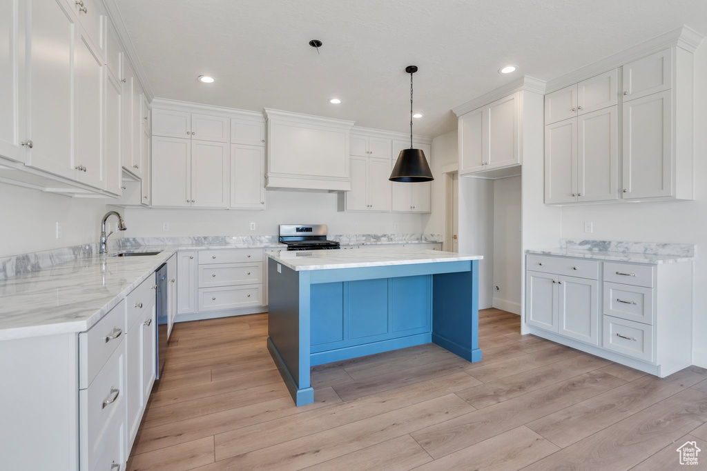 Kitchen featuring appliances with stainless steel finishes, custom exhaust hood, light wood-style flooring, white cabinetry, and recessed lighting