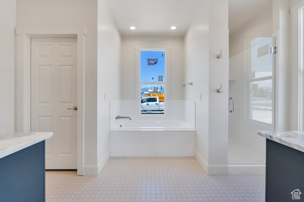 Full bath with vanity, healthy amount of natural light, a shower stall, and recessed lighting