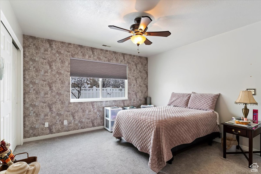 Bedroom with visible vents, baseboards, a ceiling fan, carpet flooring, and a closet