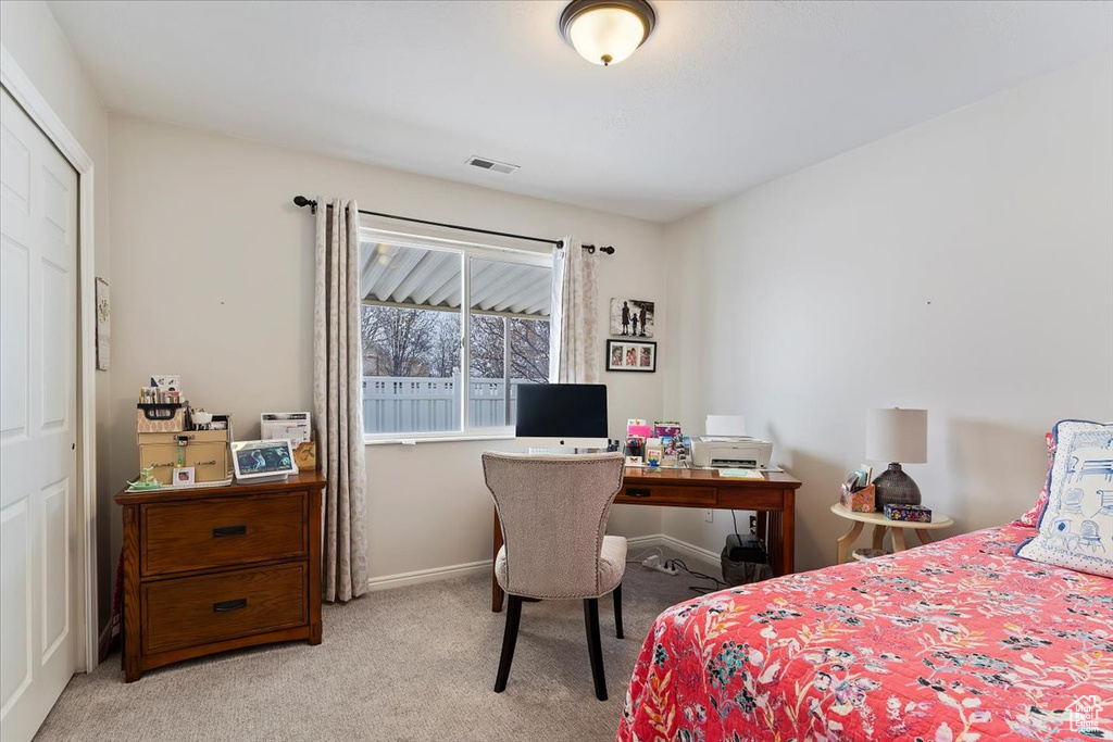Bedroom with baseboards, visible vents, and light colored carpet