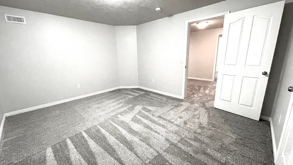 Carpeted spare room with baseboards and a textured ceiling
